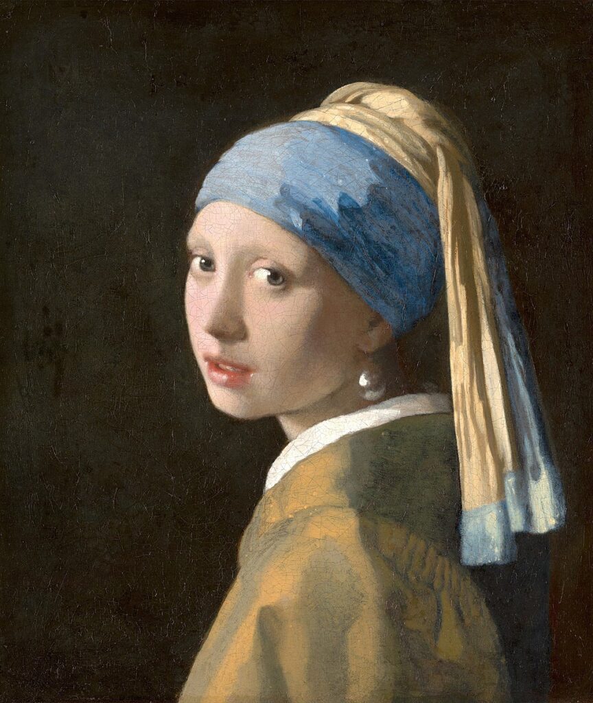 "Girl with a Pearl Earring" by Vermeer
A young woman turned towards the viewer, her enigmatic expression framed by a pearl earring and a blue headscarf.