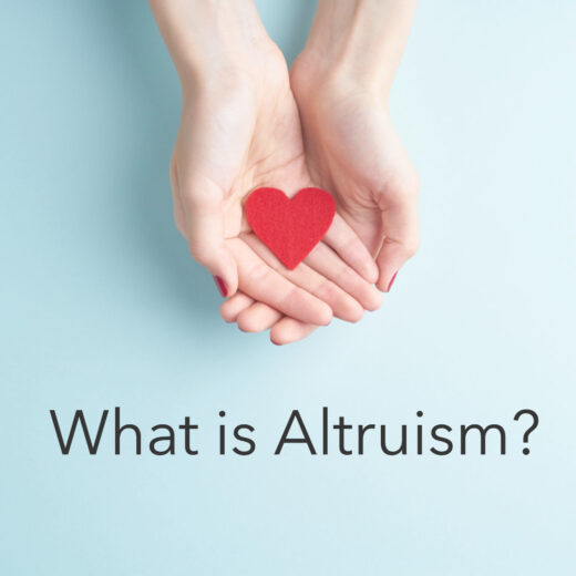 Two hands held up facing each other, forming a cradle for a symbolic heart in the middle, with the question 'What is Altruism?' written beneath, representing the exploration of the selfless concept of altruism.
